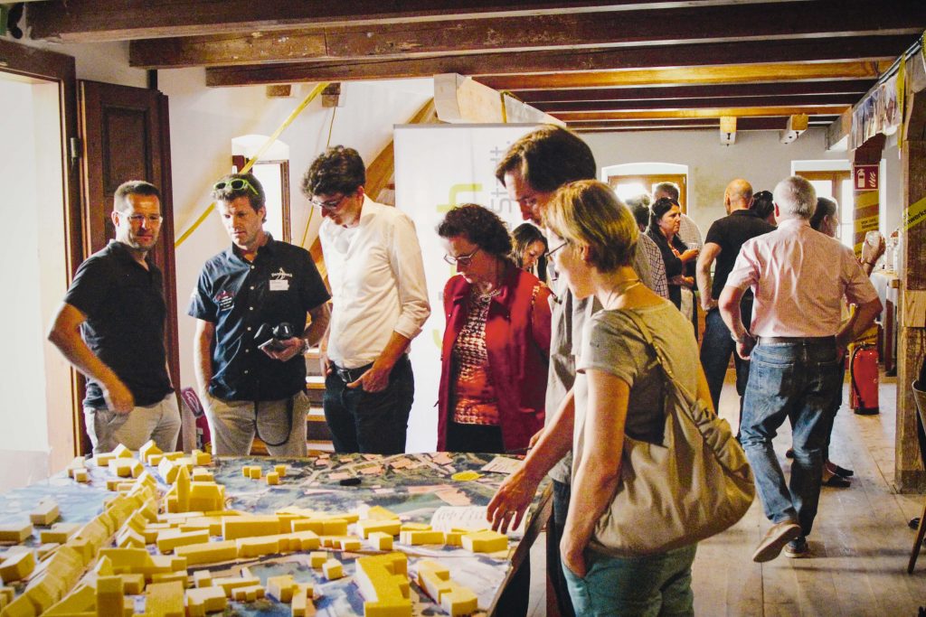 People participating in an idea workshop with model of city